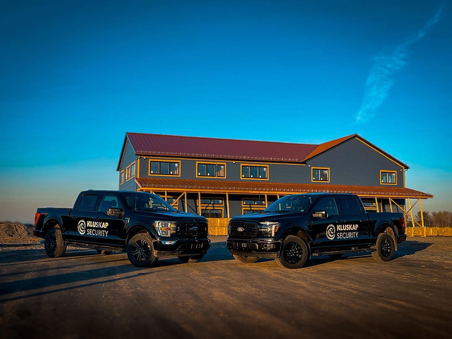 Two Kluskap Security trucks at dawn